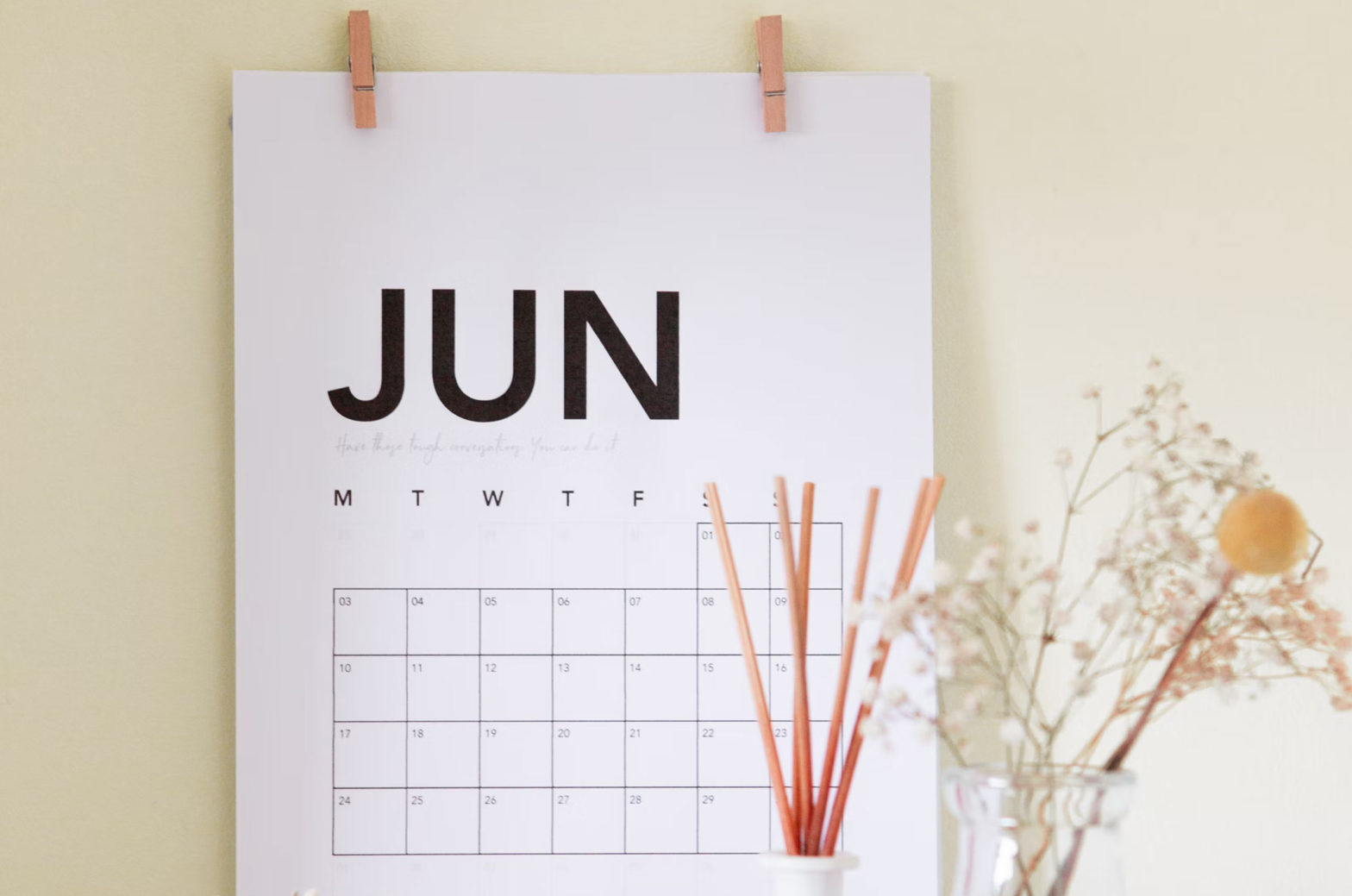A printed calendar of June 2022 with flowers in front
