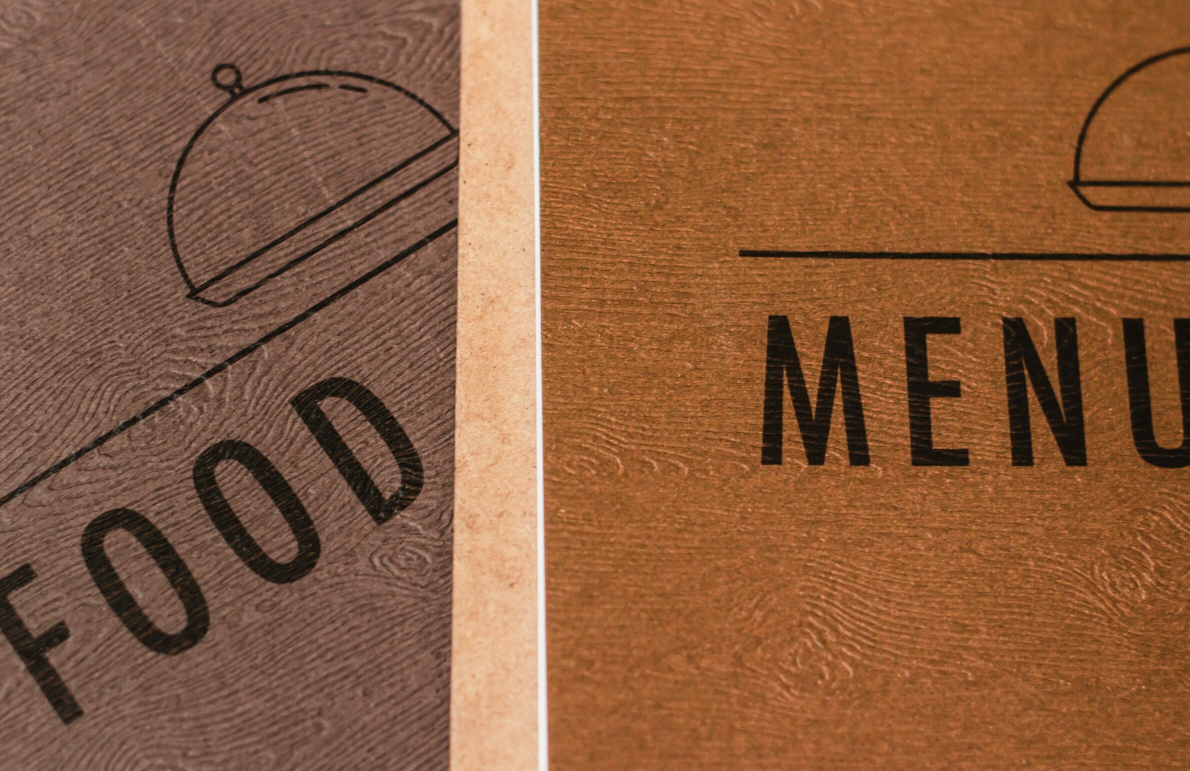 A printed food menu with an icon of a cloche on the front