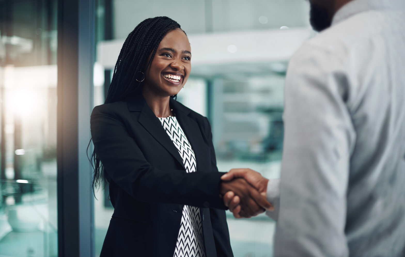 Shot of a young businesswoman shaking hands with a colleague in a modern office