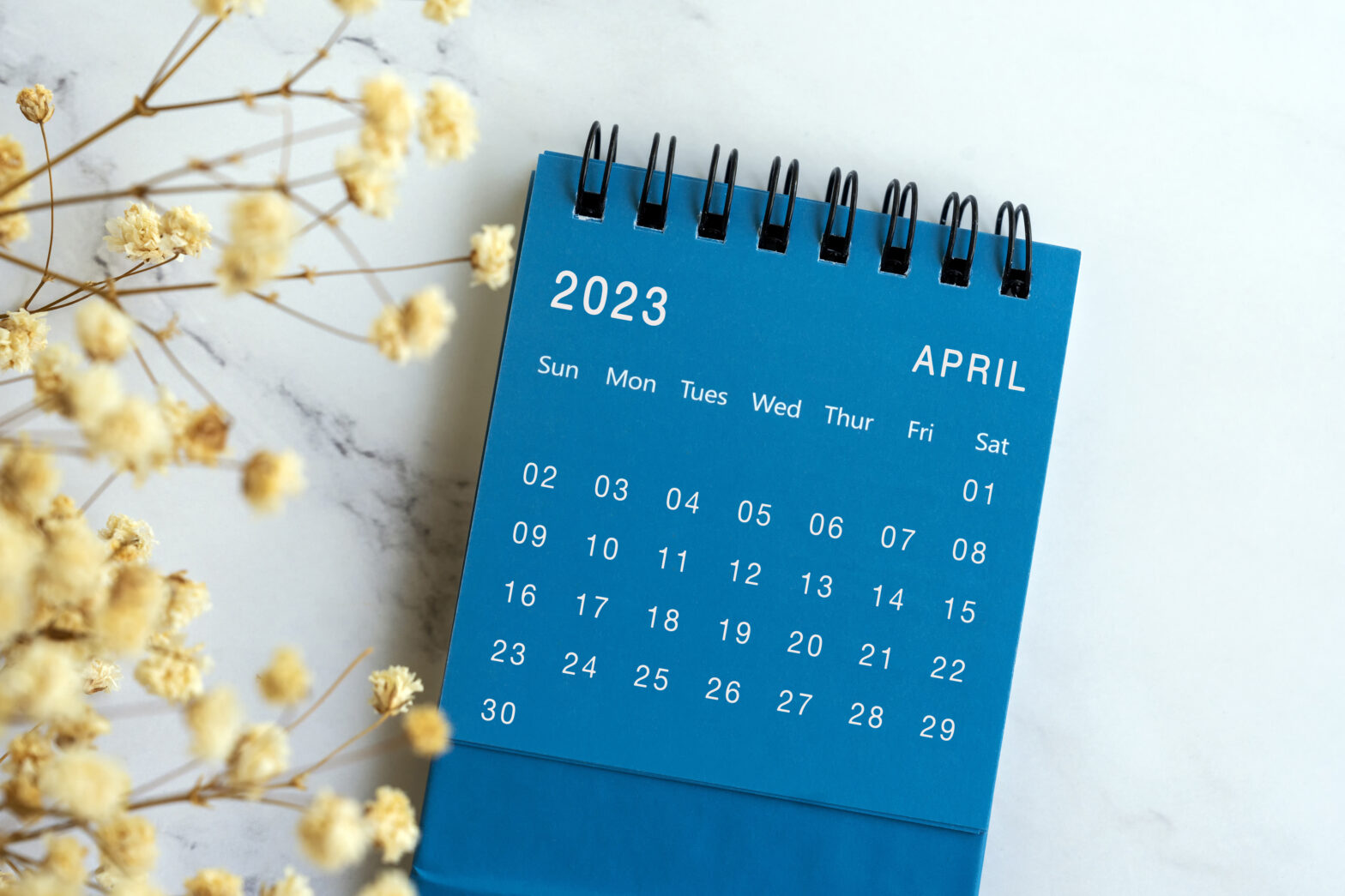 A decorative calendar in Goodwill blue showing the month of April 2023.