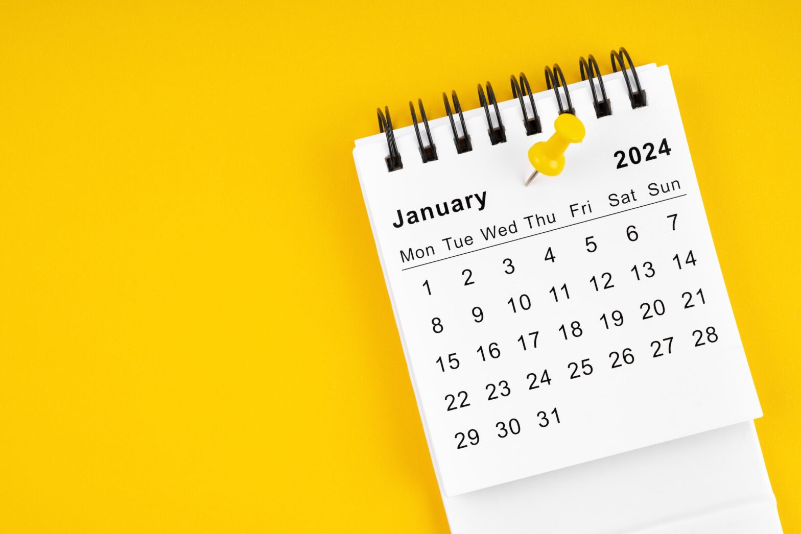 January 2024 Monthly desk calendar for 2024 year with thumbtack on yellow background.
